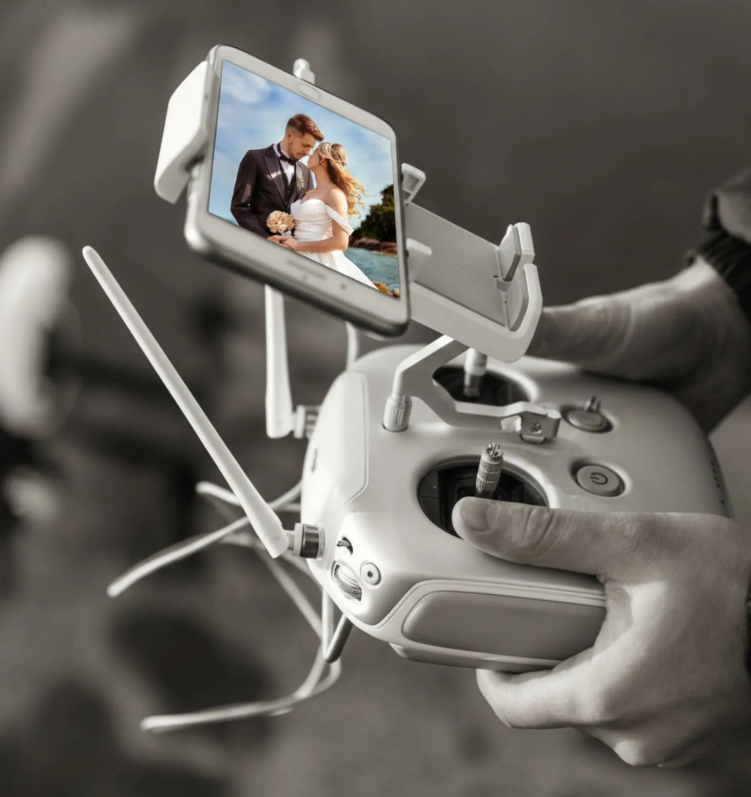 Drone controller with a phone screen previewing a wedding photo of a bride and groom